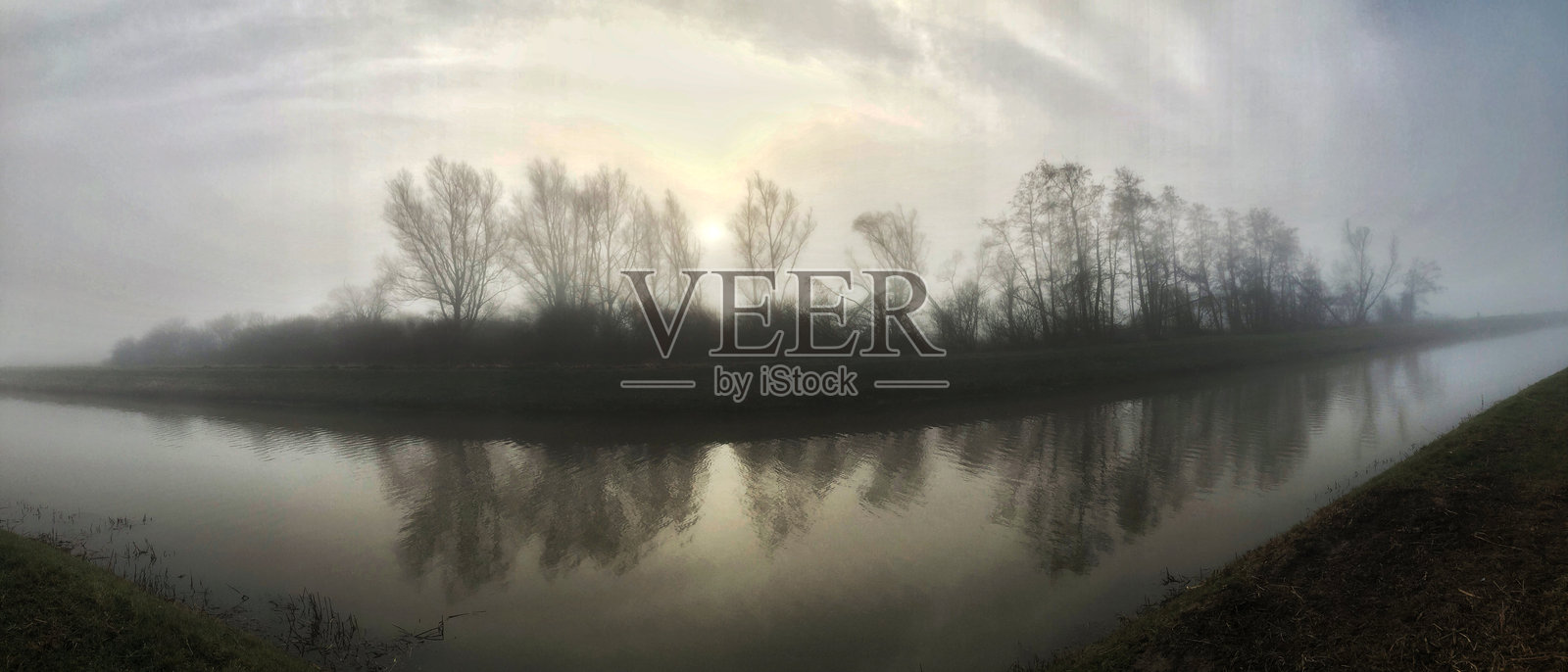 清晨雾气弥漫,日出时分靠近运河照片摄影图片