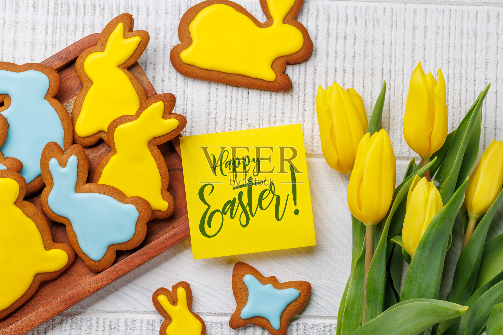 复活节兔子形状的姜饼饼干、黄色郁金香和贺卡照片摄影图片