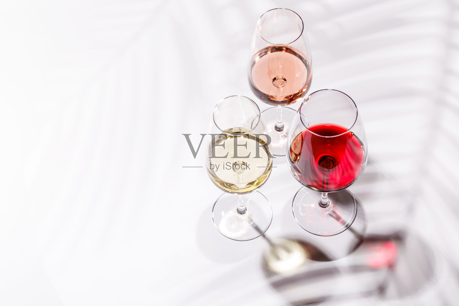 三只装满红酒、白酒和玫瑰酒的酒杯照片摄影图片