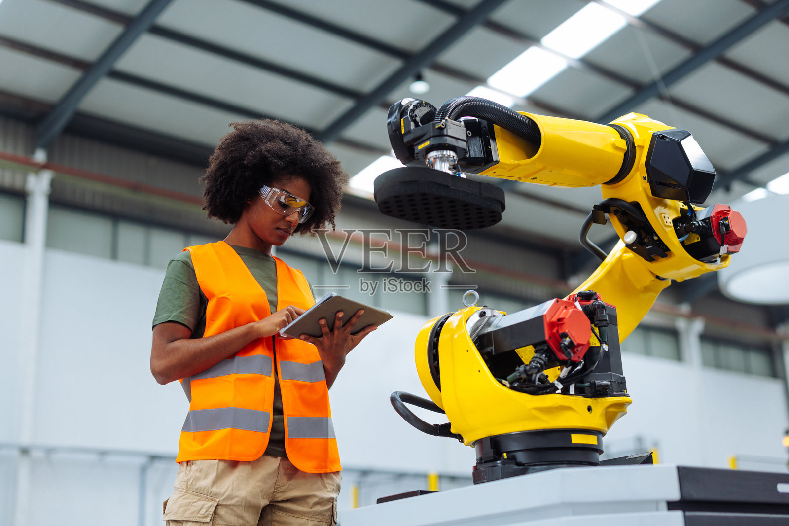 工程师在工厂环境中监控机器人手臂照片摄影图片