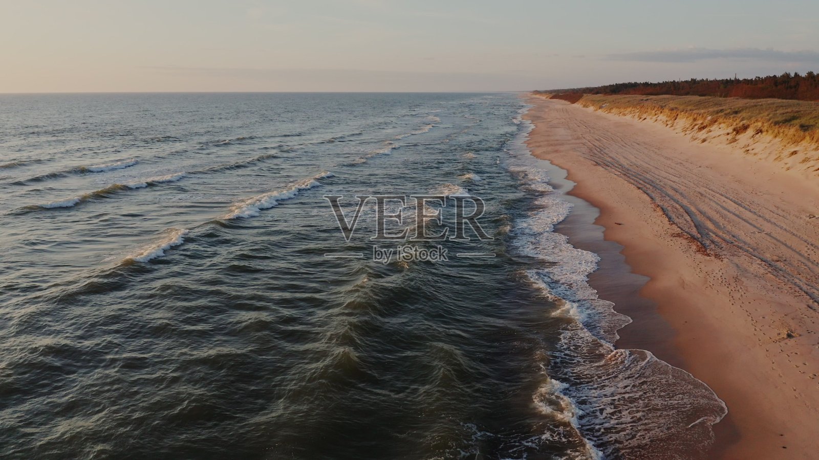 一望无际的荒凉海滩被海浪拍打照片摄影图片