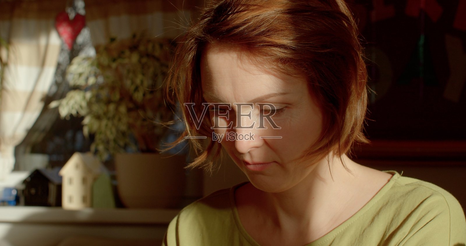 一个室内场景,展现了一位沐浴在柔和光线和自然元素中的女性照片摄影图片