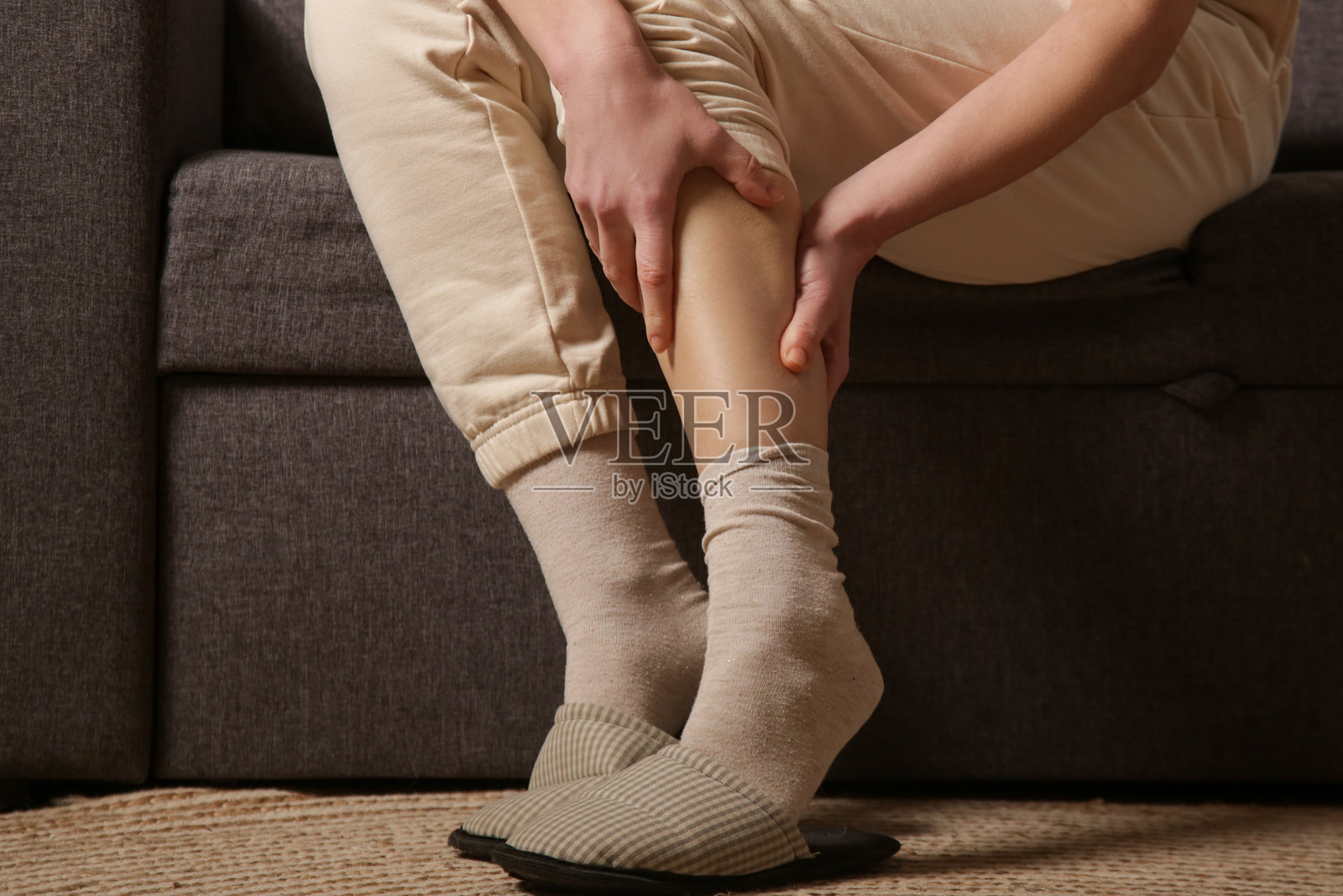 女性正在处理小腿肌肉疼痛。照片摄影图片