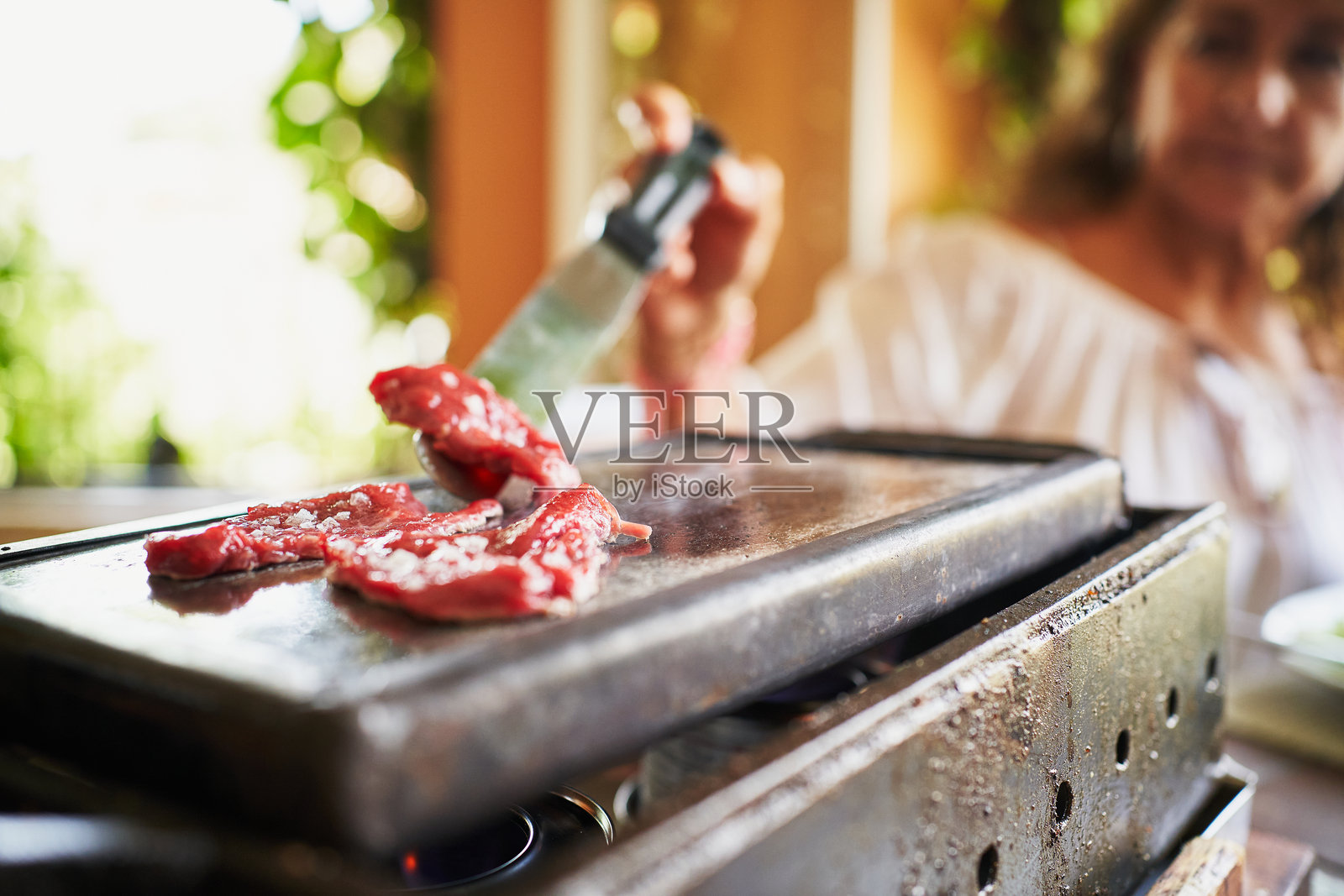 顾客在地中海餐厅的热烤架上翻转肉类照片摄影图片