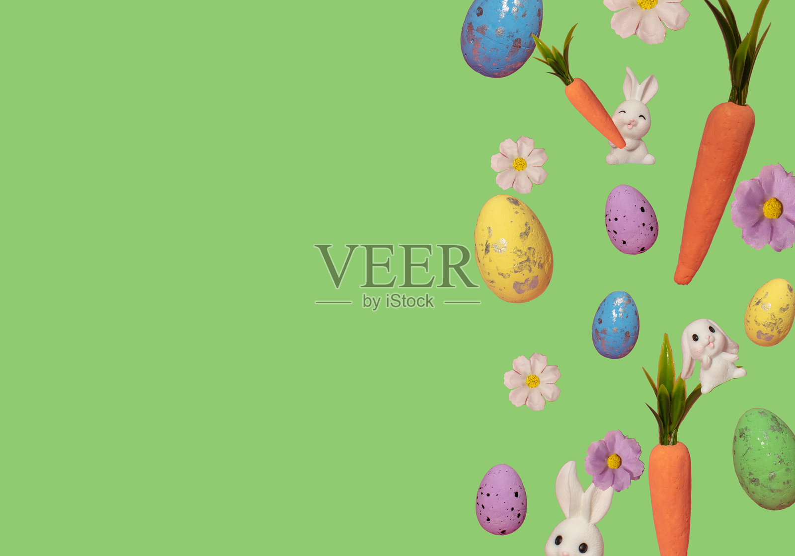 以胡萝卜、鸡蛋、花朵和兔子在淡绿色背景上制作的复活节布局。创意简约的节日概念。照片摄影图片