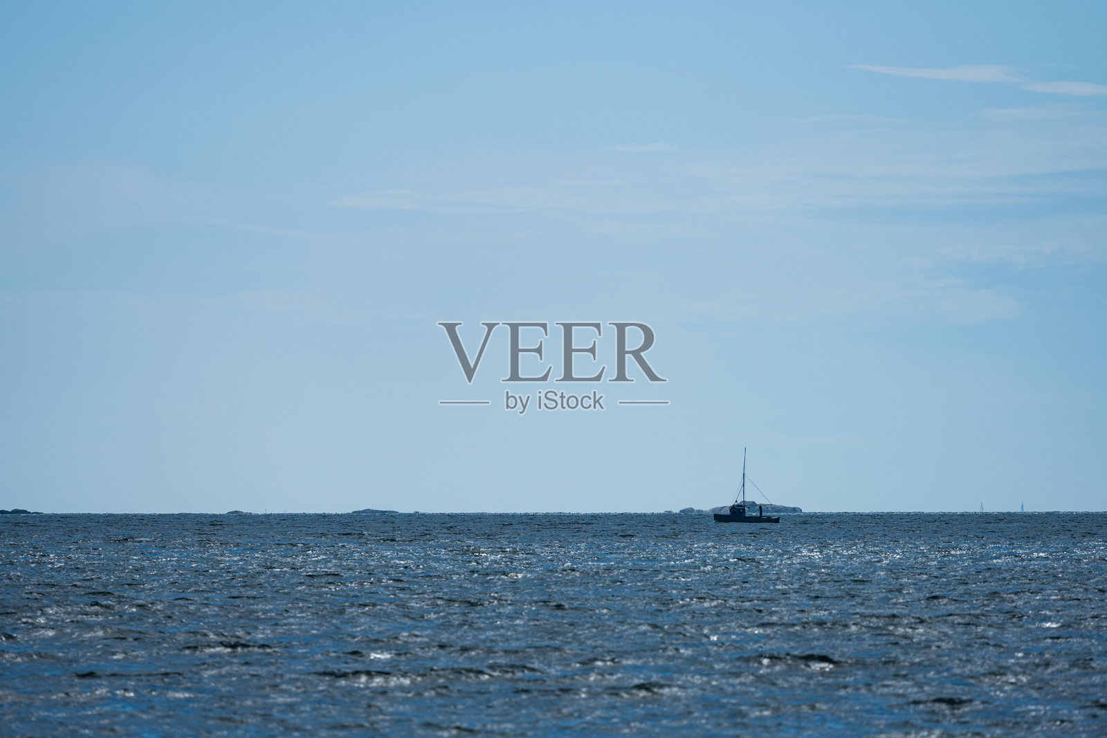 阳光明媚、微风拂面的海上小渔船。照片摄影图片