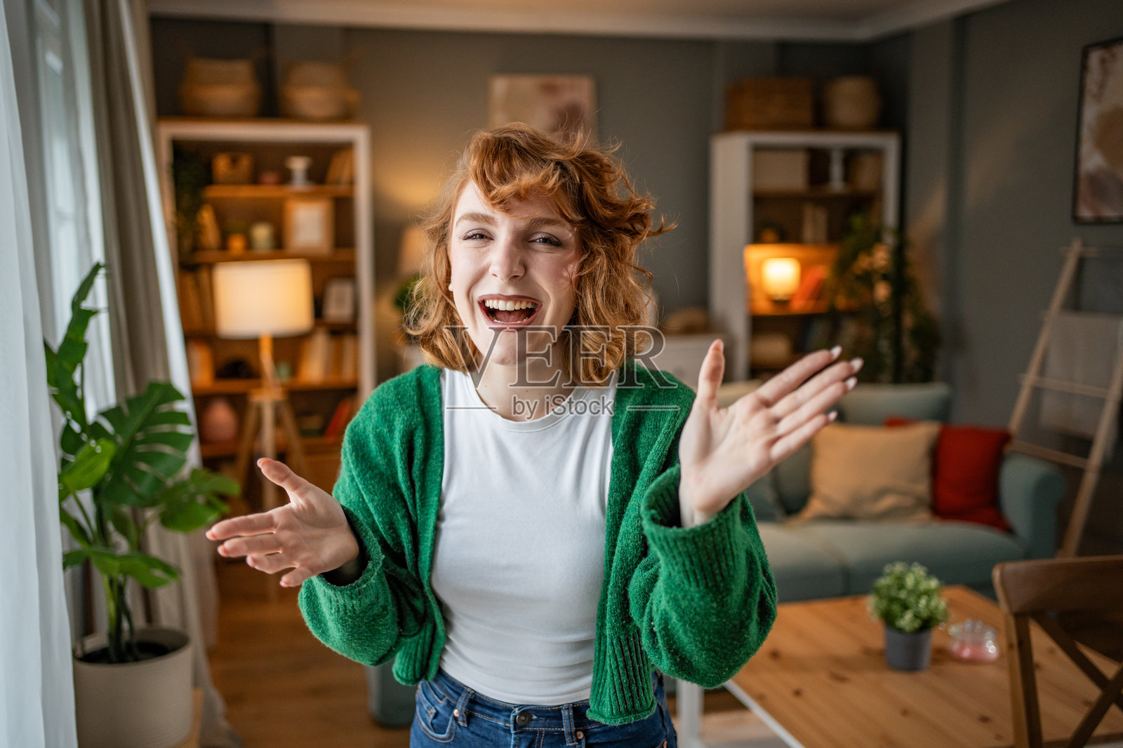 年轻女性在客厅里笑着并做手势照片摄影图片