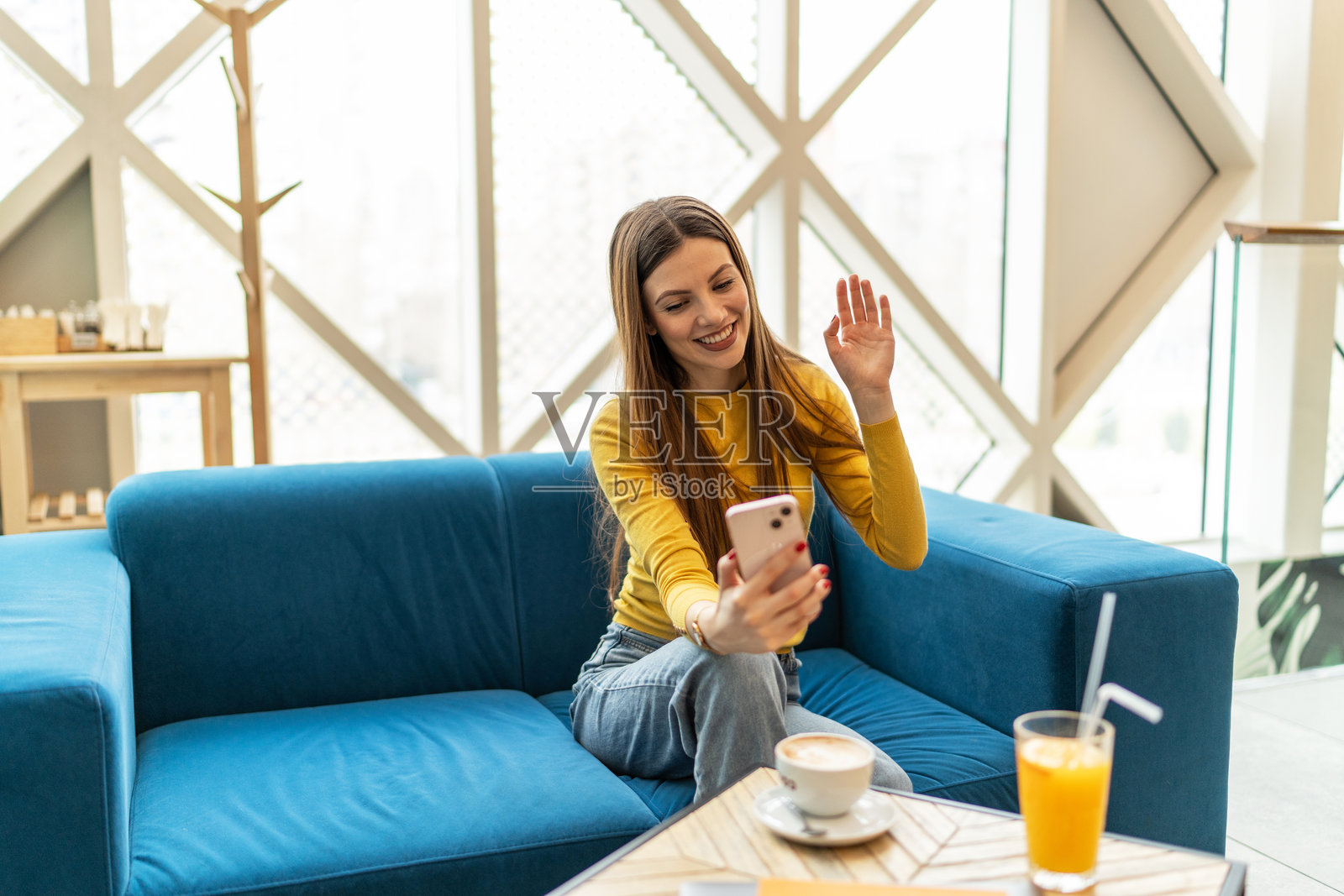 年轻快乐的女性在咖啡店使用智能手机照片摄影图片