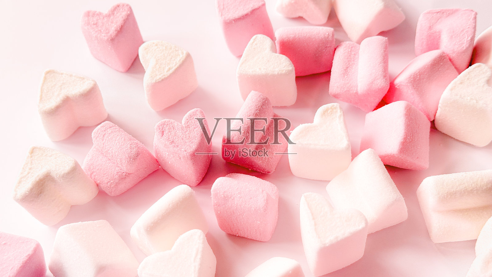 情人节粉色心形棉花糖作为背景和纹理。背景中有齐夫尔,留有文字空间,心形图案散落其间。照片摄影图片