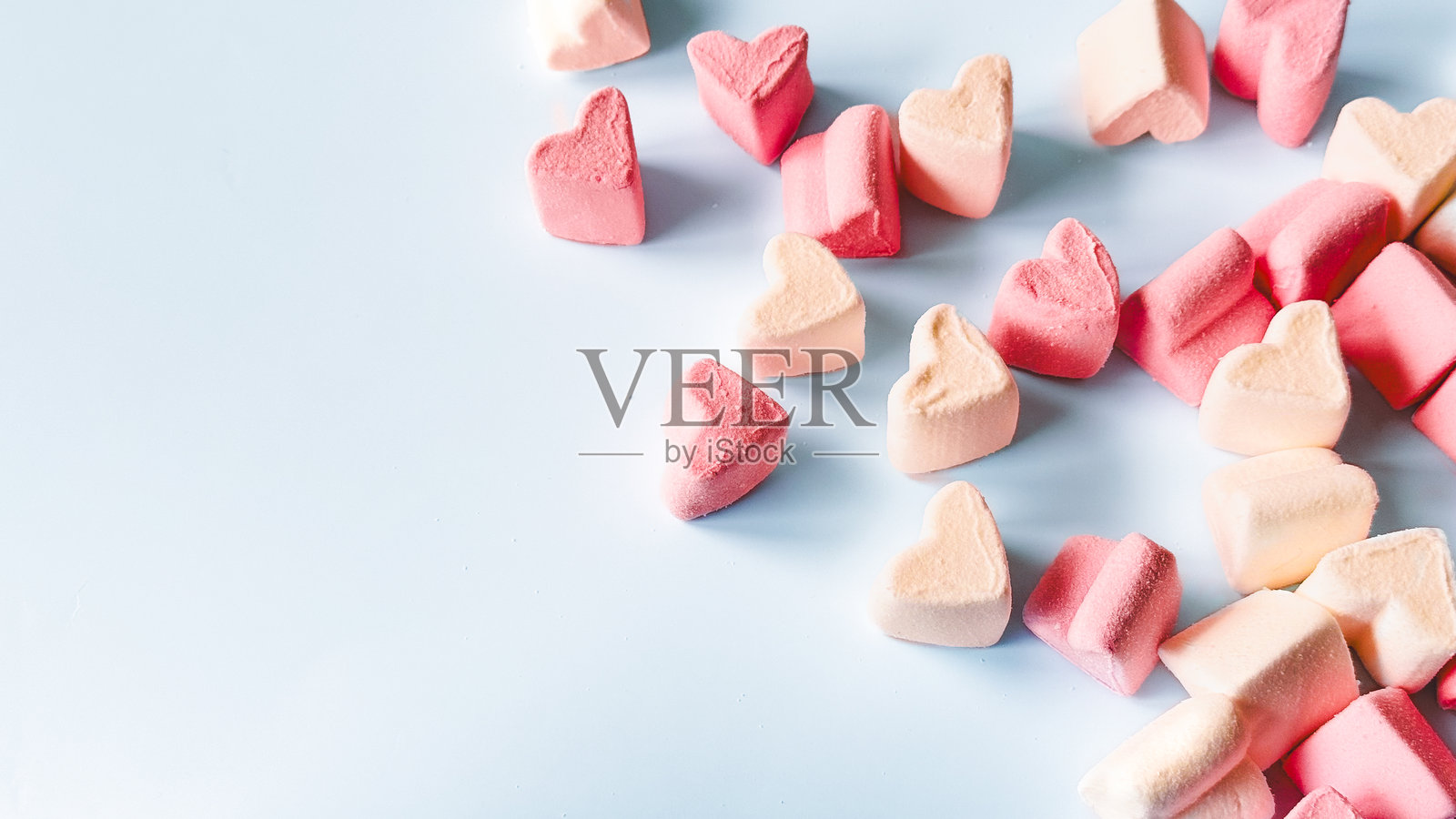 情人节粉色心形棉花糖作为背景和纹理。背景中有齐夫尔,留有文字空间,心形图案散落其间。照片摄影图片