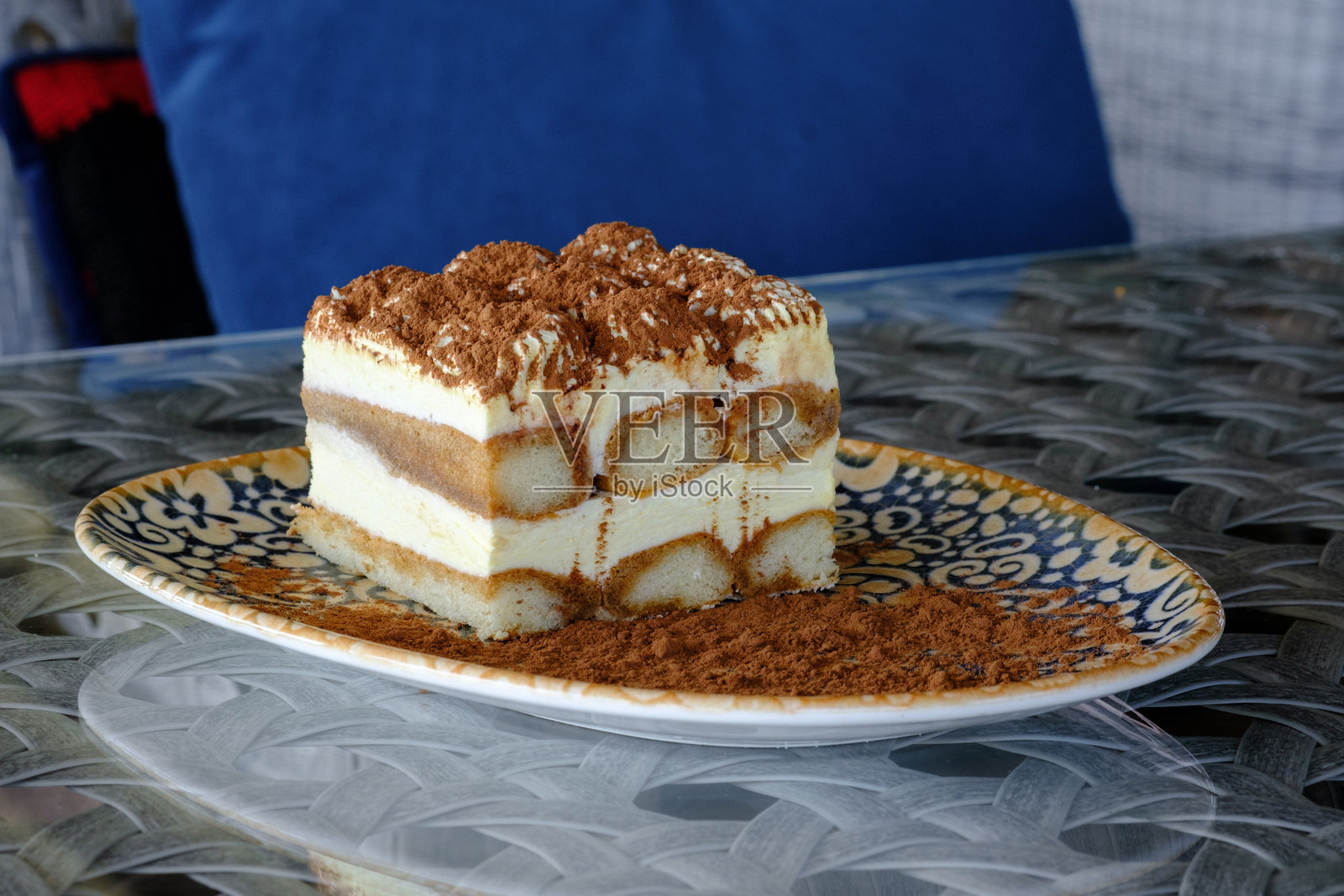 一片美味的提拉米苏,层层叠叠的奶油馅和浸泡在咖啡中的手指饼干,撒上可可粉。照片摄影图片