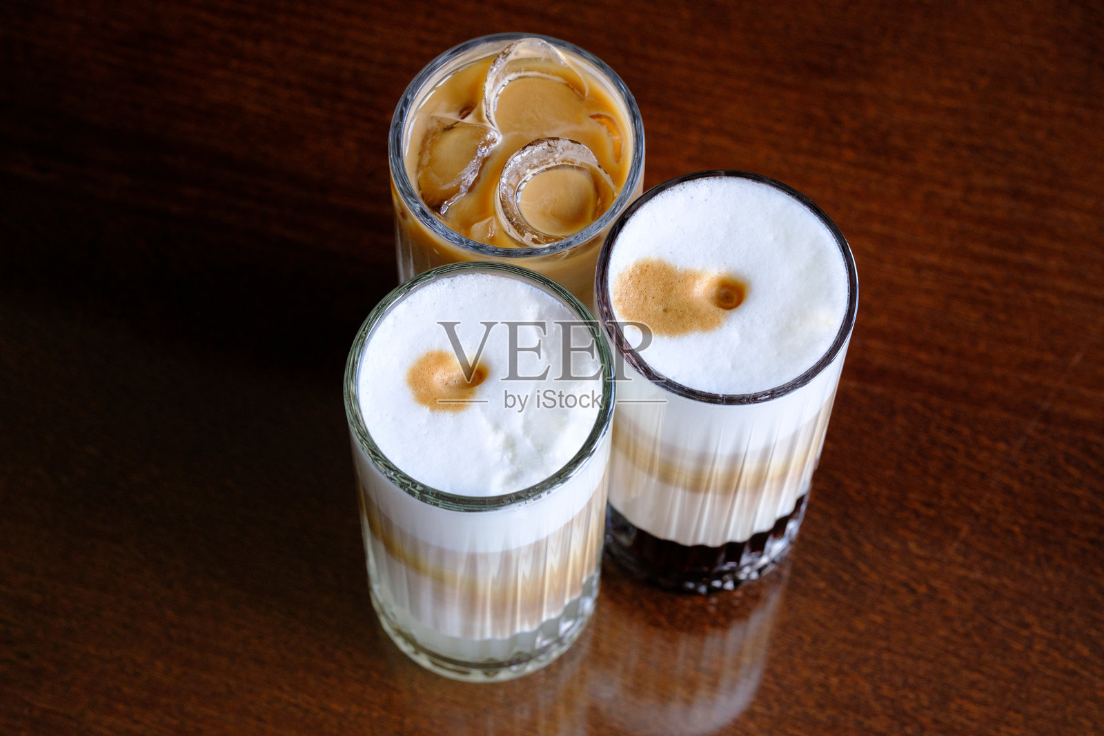 三杯冰咖啡,奶和泡沫的浓度各不相同照片摄影图片