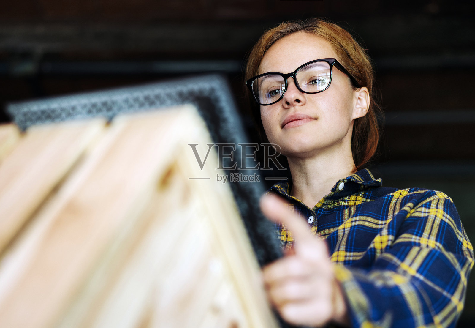 戴眼镜的女性正在测量木箱照片摄影图片
