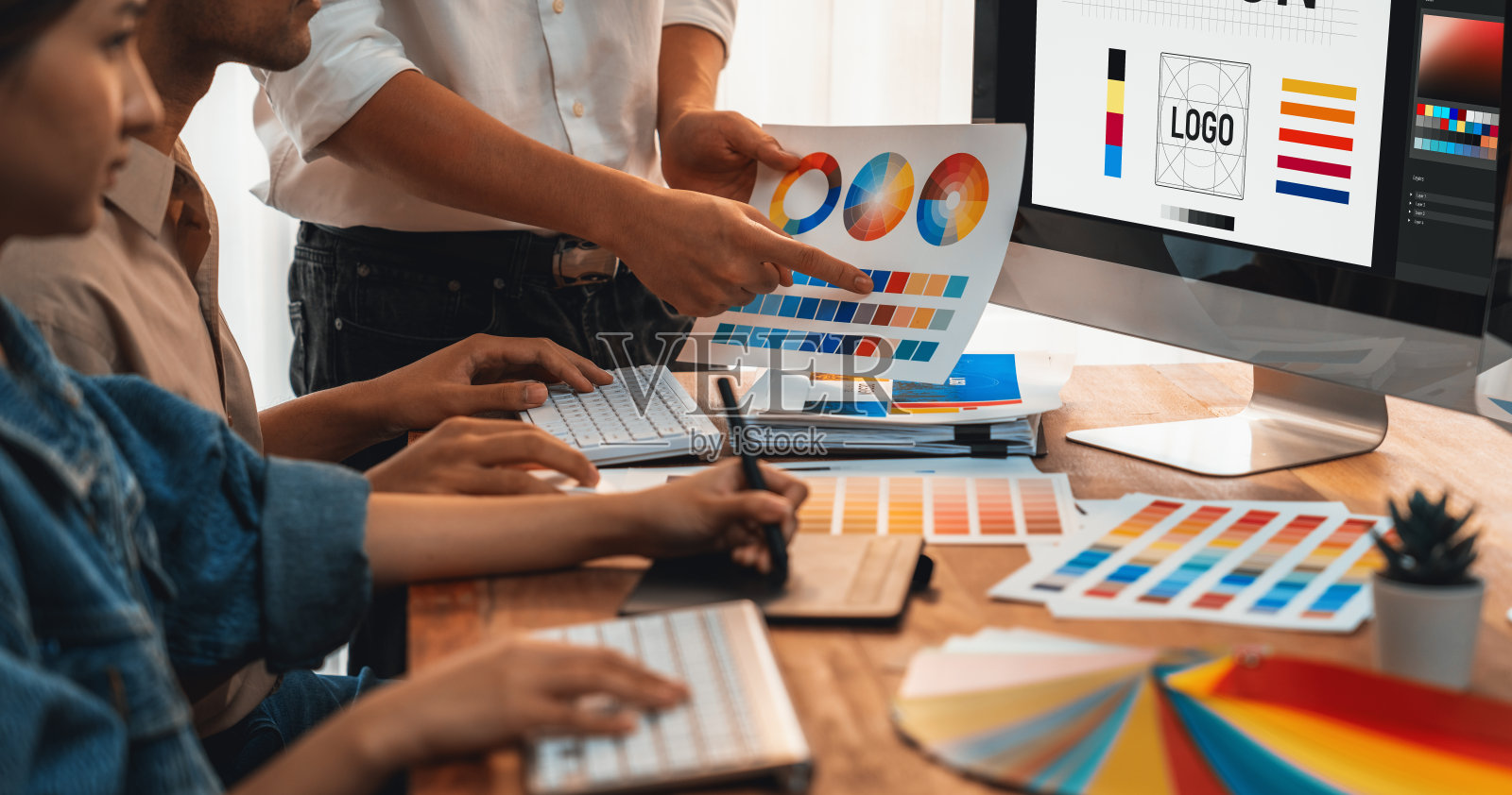 平面设计师使用数位笔在笔记本电脑上工作。照片摄影图片