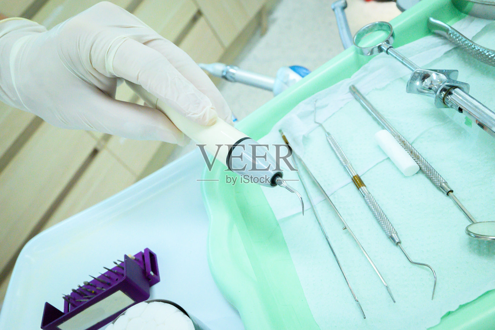 牙医手持牙科卫生工具。牙医用的器械托盘,口腔卫生元素,专业工具。闭合角度,特写。照片摄影图片