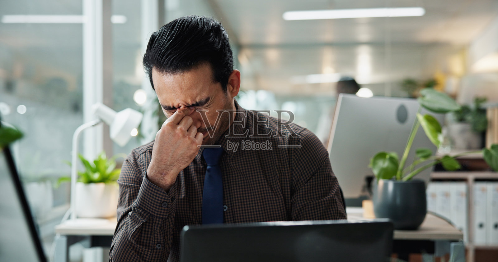 沮丧的商人在办公室因压力、债务或公司破产而感到头晕和头痛。这个员工因工作压力、紧张或超负荷的截止日期而感到疲惫和偏头痛。照片摄影图片