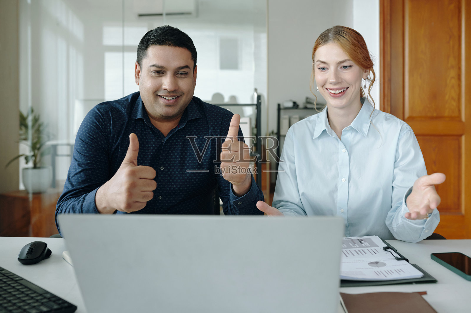 微笑的同事们在办公室进行虚拟会议照片摄影图片