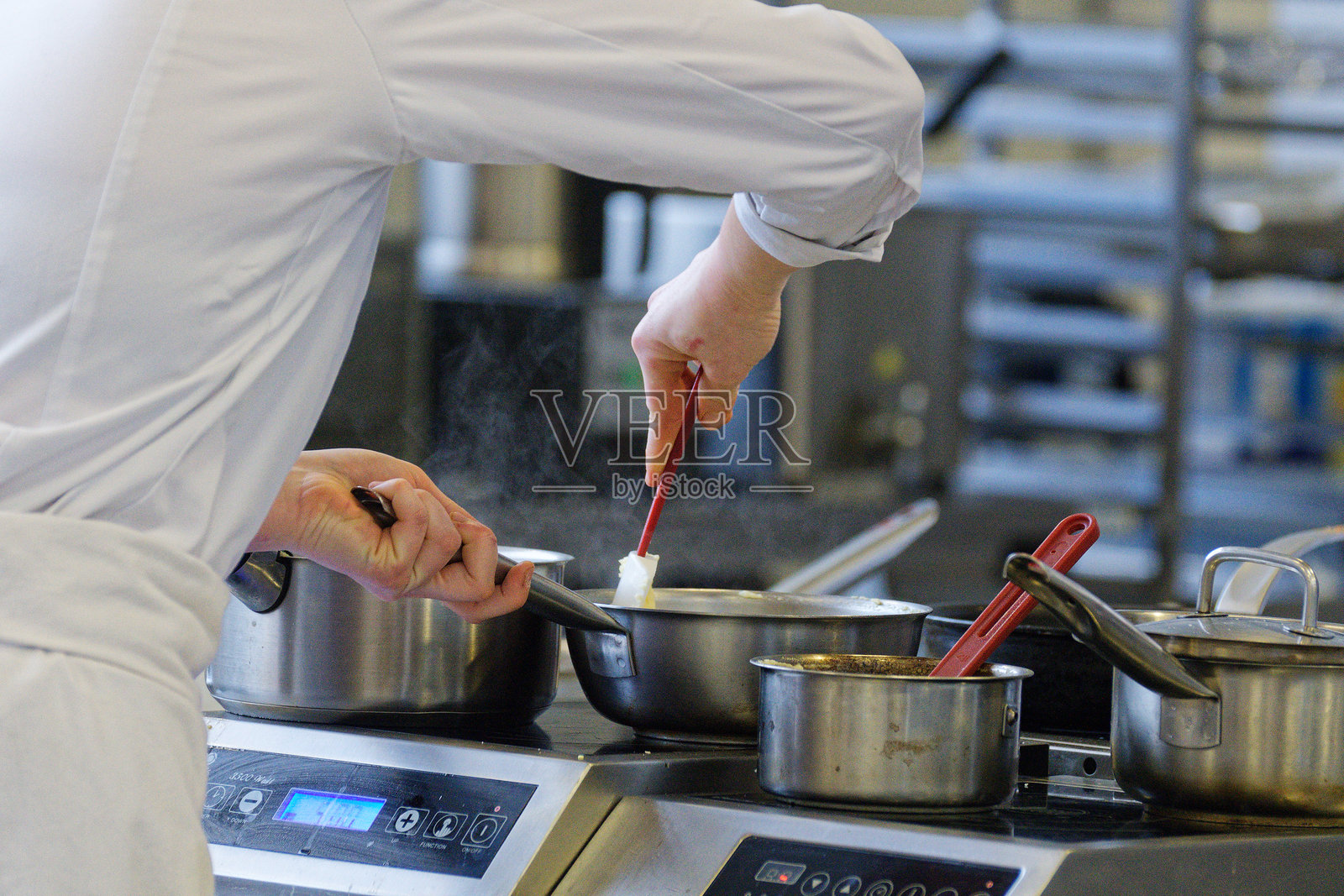 厨师在火上忙碌地烹饪锅具照片摄影图片