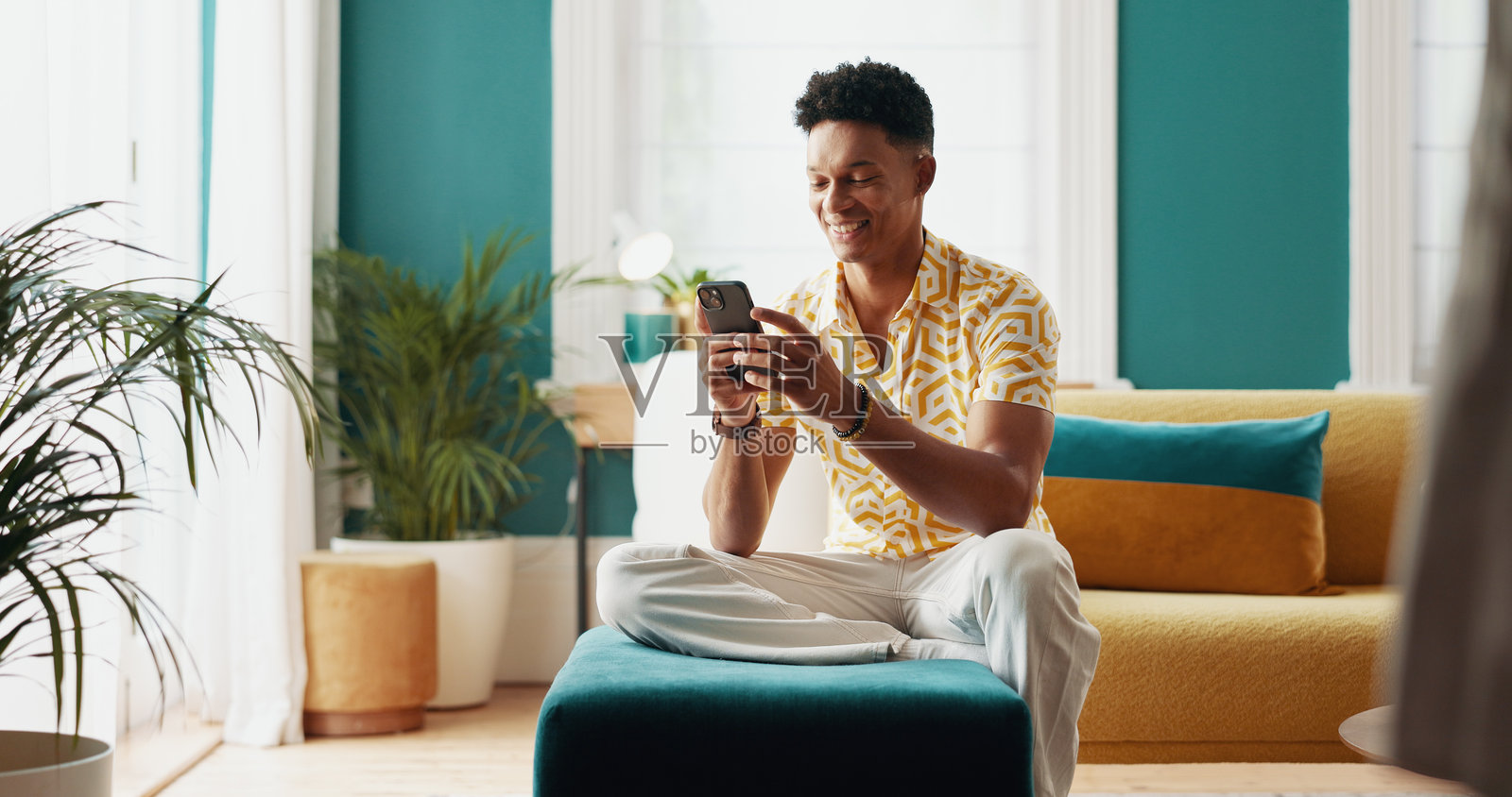 快乐的男学生在家中查看教育结果、大学申请和录取通知。他正在用手机接收关于入学、奖学金反馈和批准通知的好消息。照片摄影图片