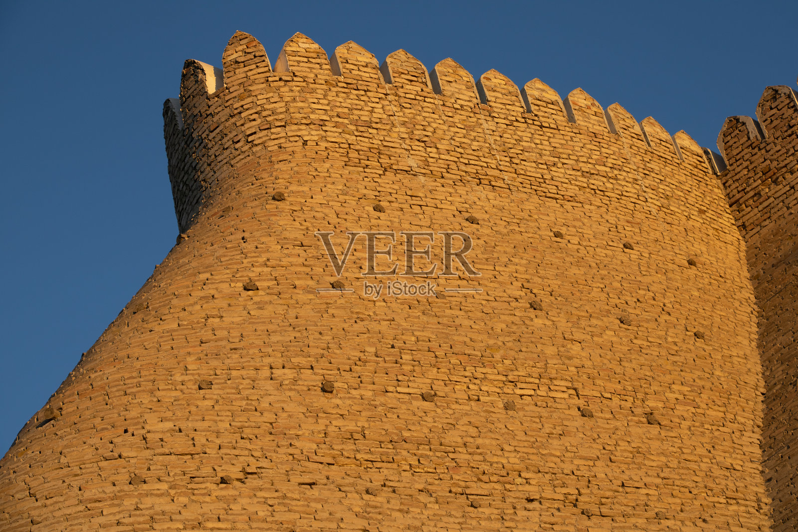 乌兹别克斯坦布哈拉 - 2024年10月17日:金色晨光中的阿克城堡墙照片摄影图片