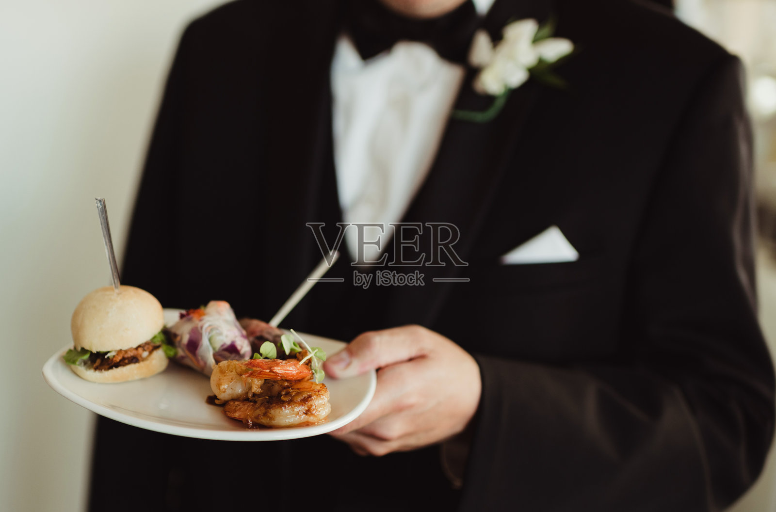 新郎在婚礼招待会上手持开胃菜盘照片摄影图片