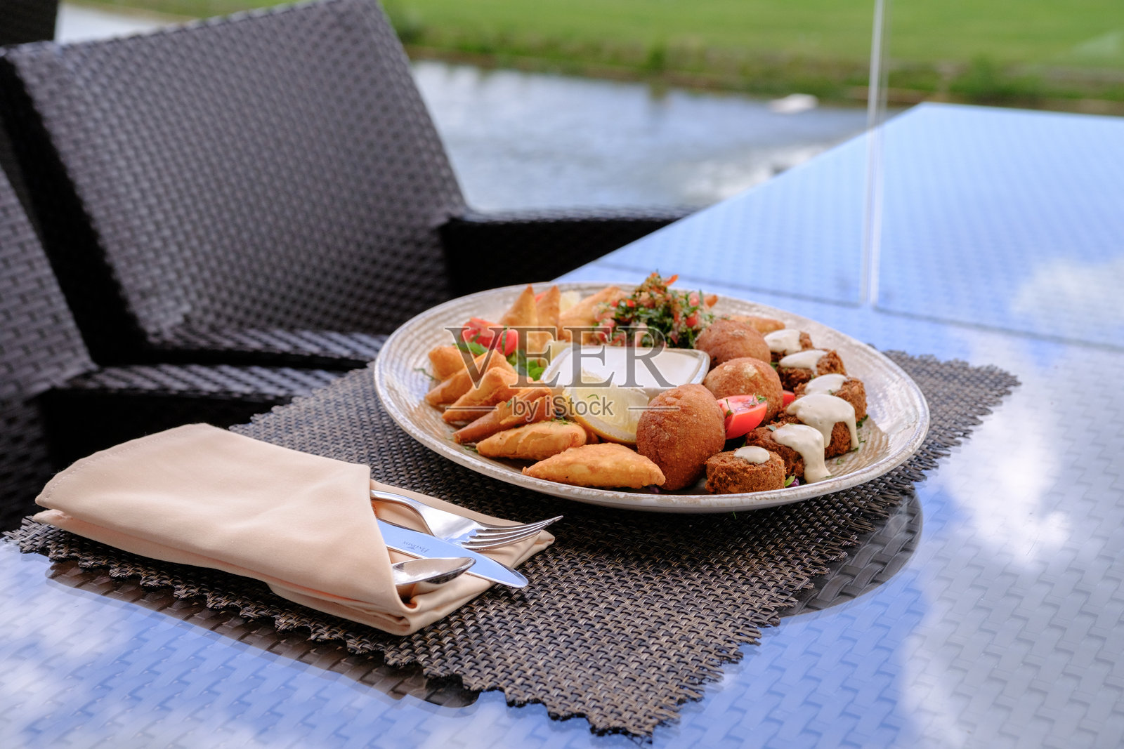 地中海开胃菜拼盘,包含油炸糕点、法拉费尔和蘸酱,在户外享用照片摄影图片