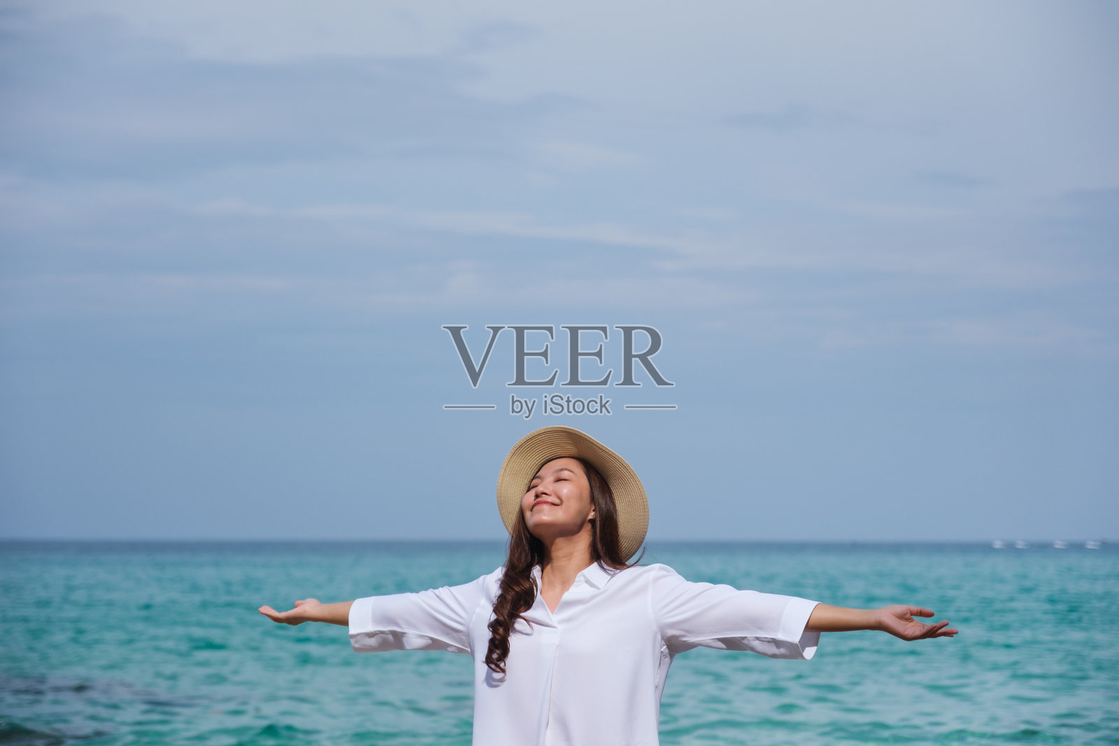 海边一位年轻女性张开双臂的肖像照片摄影图片