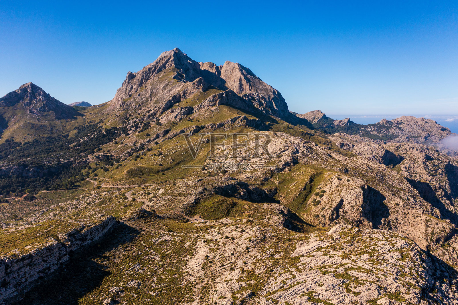马洛卡的特拉蒙塔纳山脉壮观的鸟瞰图,崎岖的山峰、深蓝色的地中海,以及漂浮在上方的柔软云朵。令人叹为观止的自然风光展示了这个岛屿的美丽。照片摄影图片