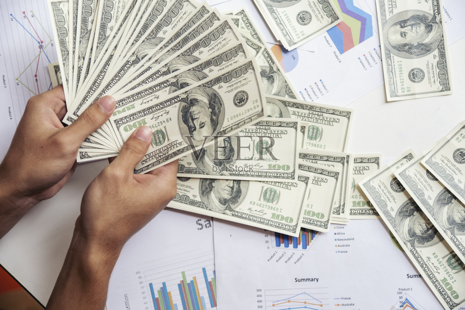 手握贷款美元钞票进行财务支付。男人的手展示着100美元的现金交易。商人计算钞票,体现贿赂和腐败的概念。照片摄影图片