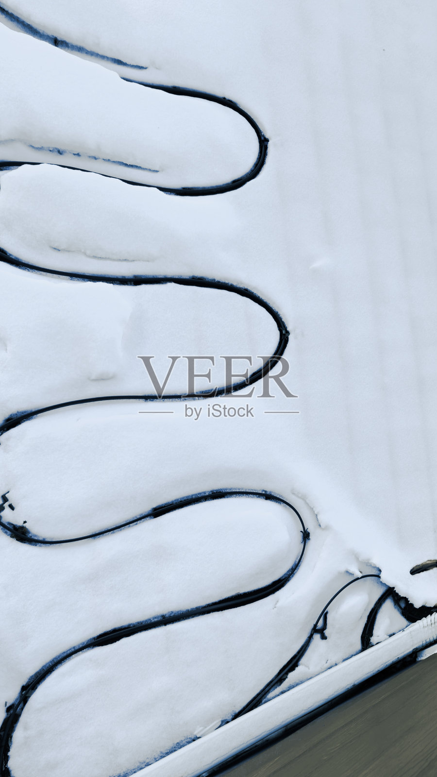 从上方俯视安装在沥青瓦屋顶上的除冰系统和积雪照片摄影图片