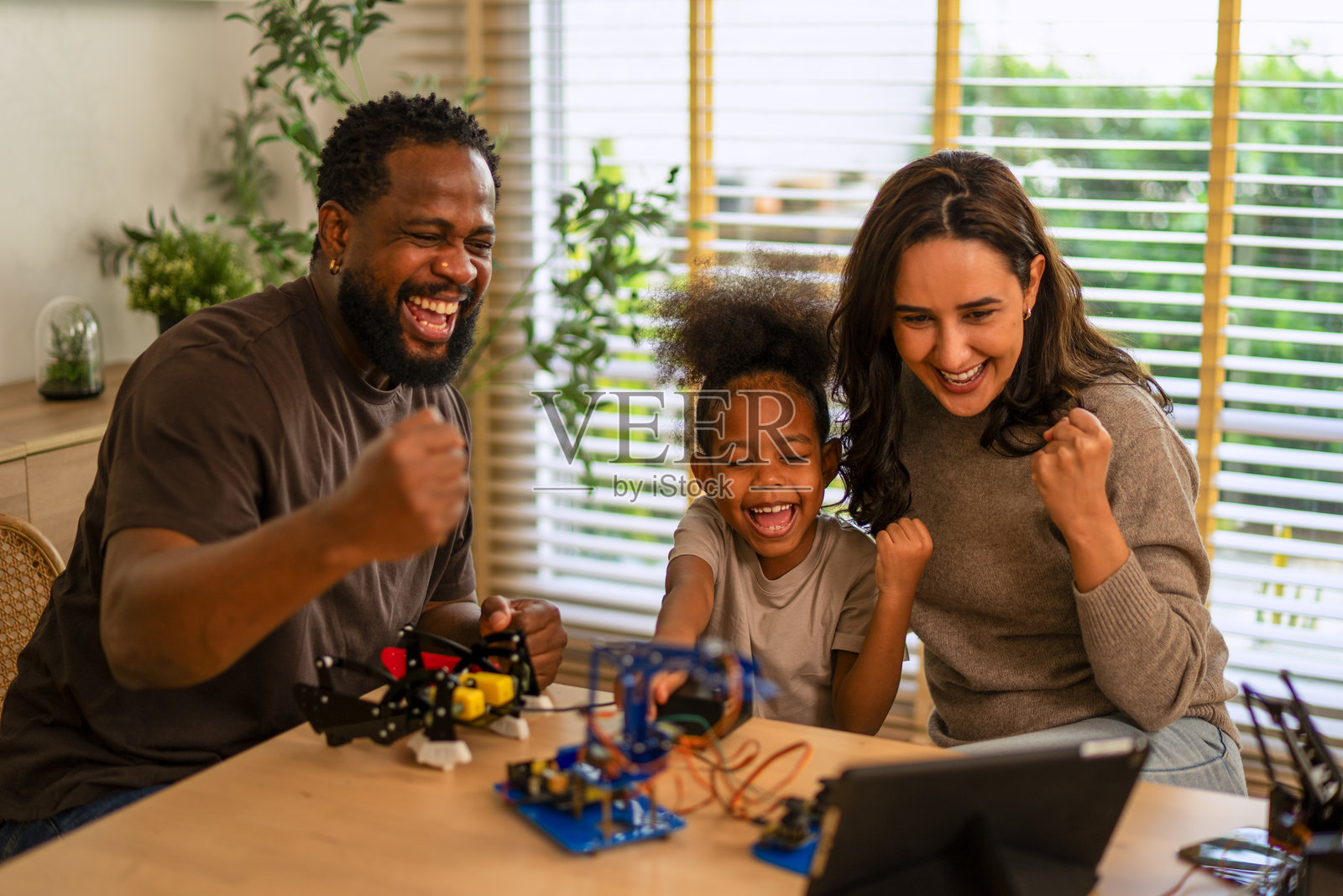 母亲正在教女儿关于机器人物体的知识。照片摄影图片