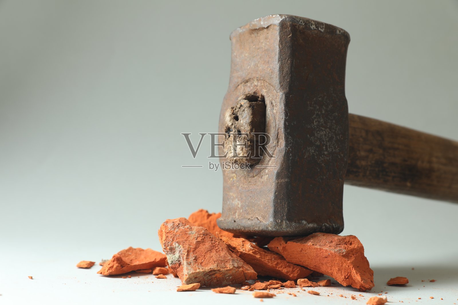 一把大锤和一些破砖块放在灰色背景上,特写。留有文字空间。照片摄影图片