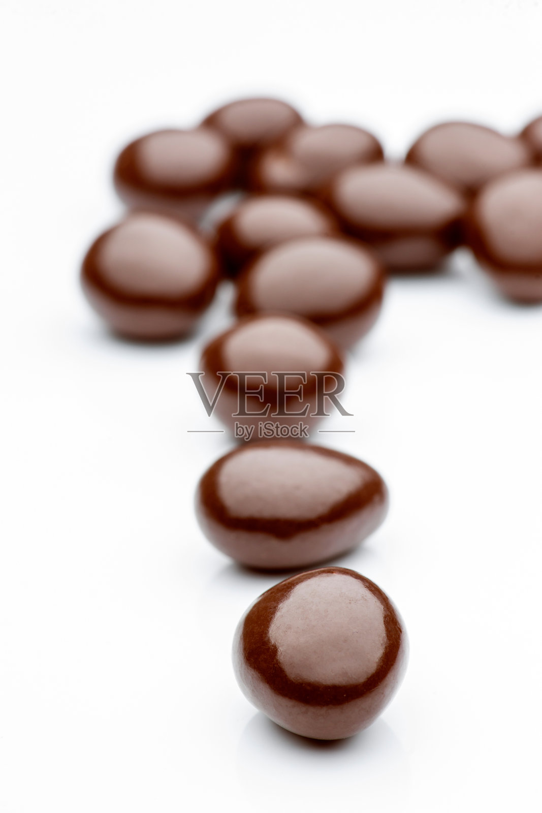 在白色背景上形成对角线的巧克力裹花生照片摄影图片