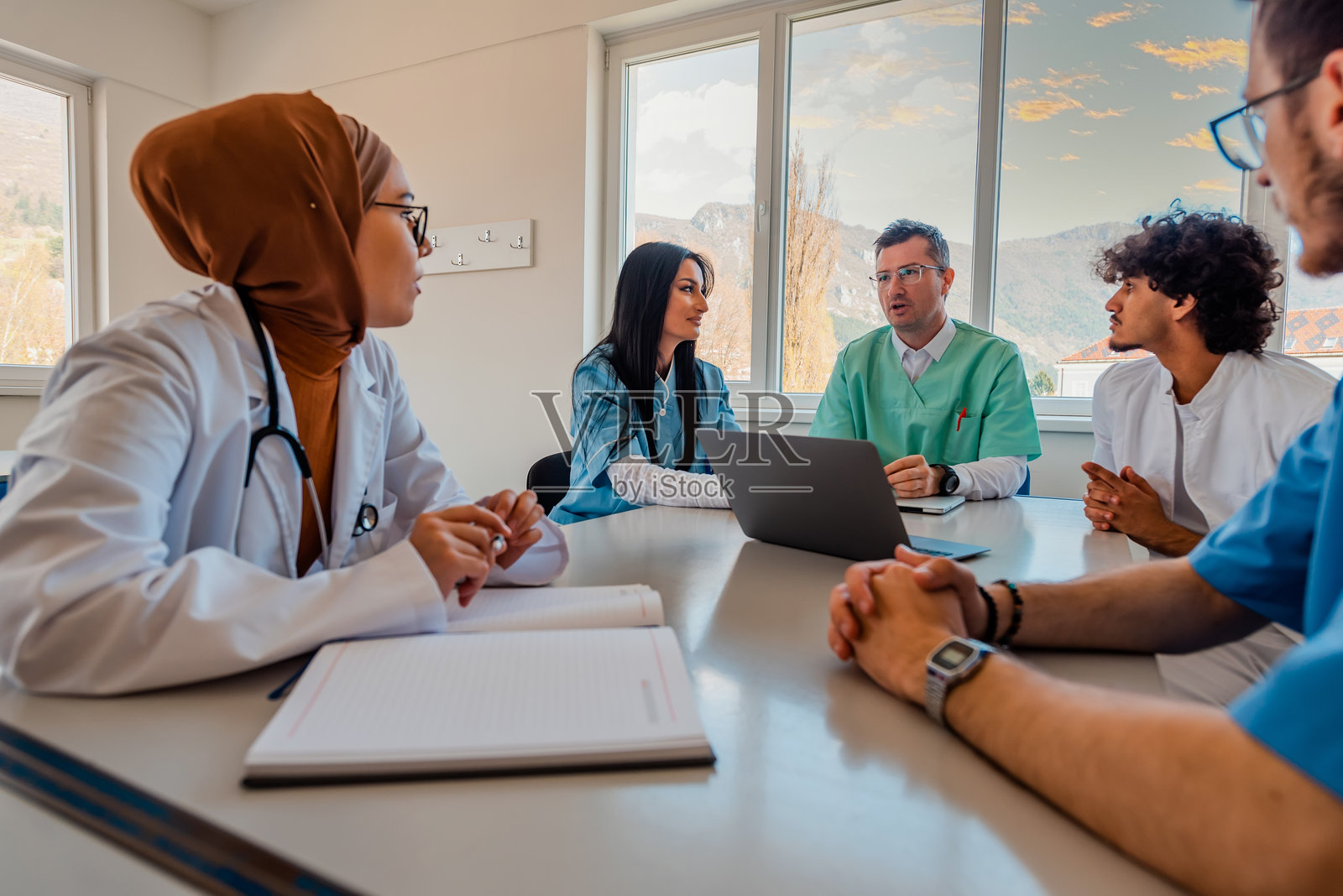一组医生在会议室讨论。照片摄影图片