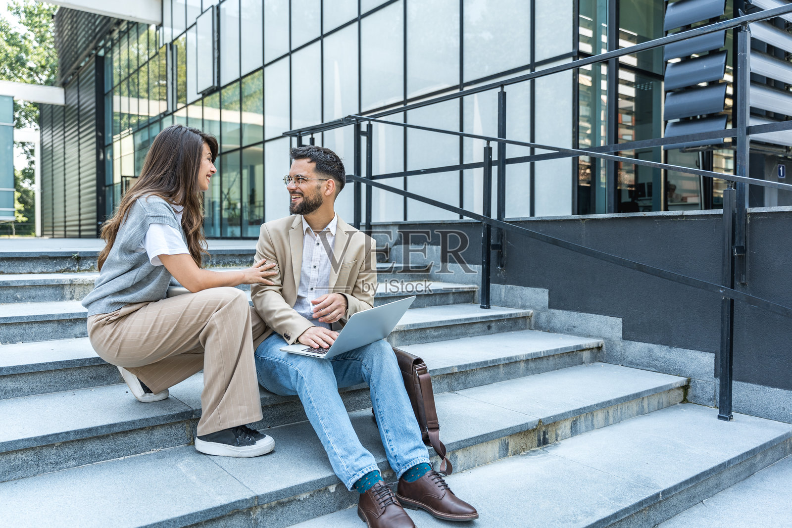 专业职业,办公室工作人员。商务人士在办公大楼会议前会面,讨论演讲主题的计划和策略。金融与经济。照片摄影图片