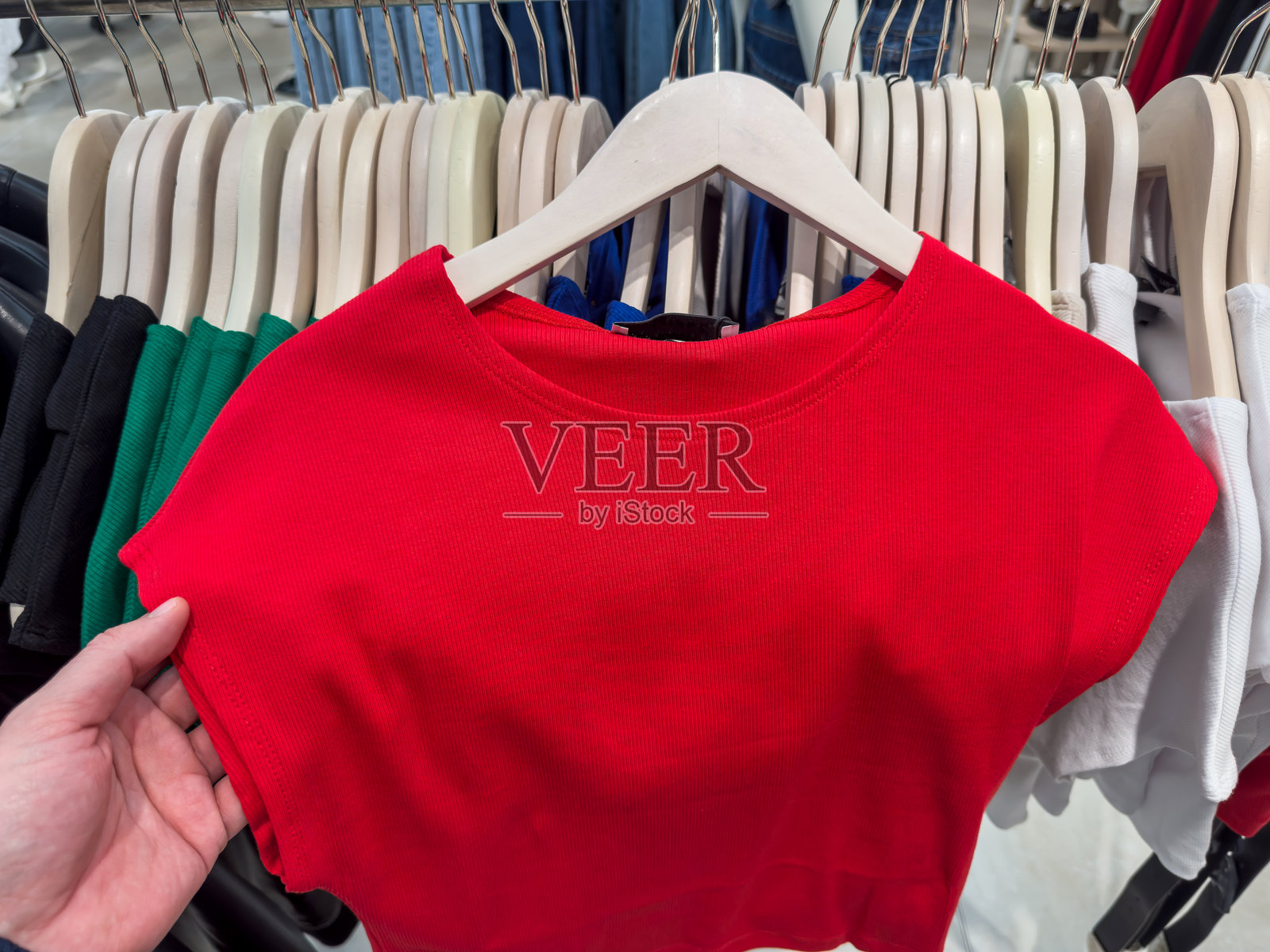 特写镜头下的女性在精品店挑选衬衫。时尚服装购物的概念。照片摄影图片