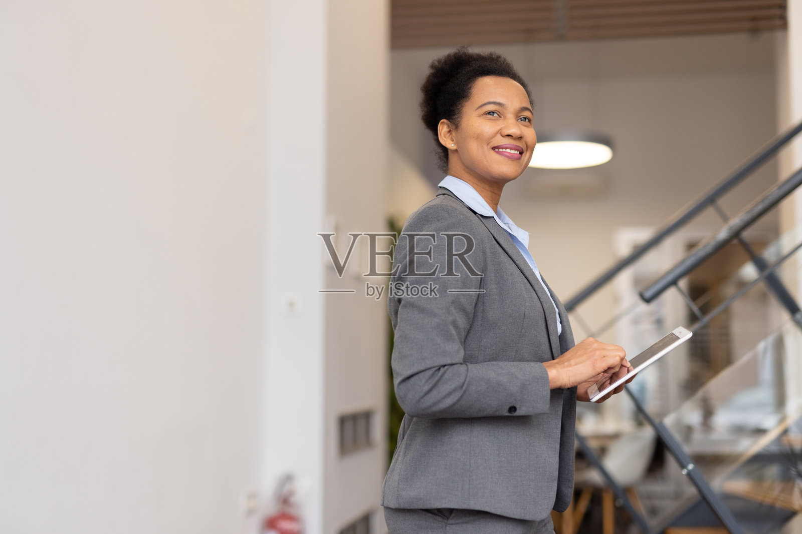 一位经验丰富的非裔美国高管正在分析数字平板上的报告照片摄影图片