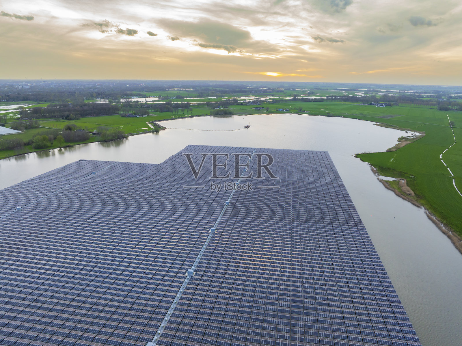 春季日落时,漂浮在湖面上的太阳能电池板照片摄影图片