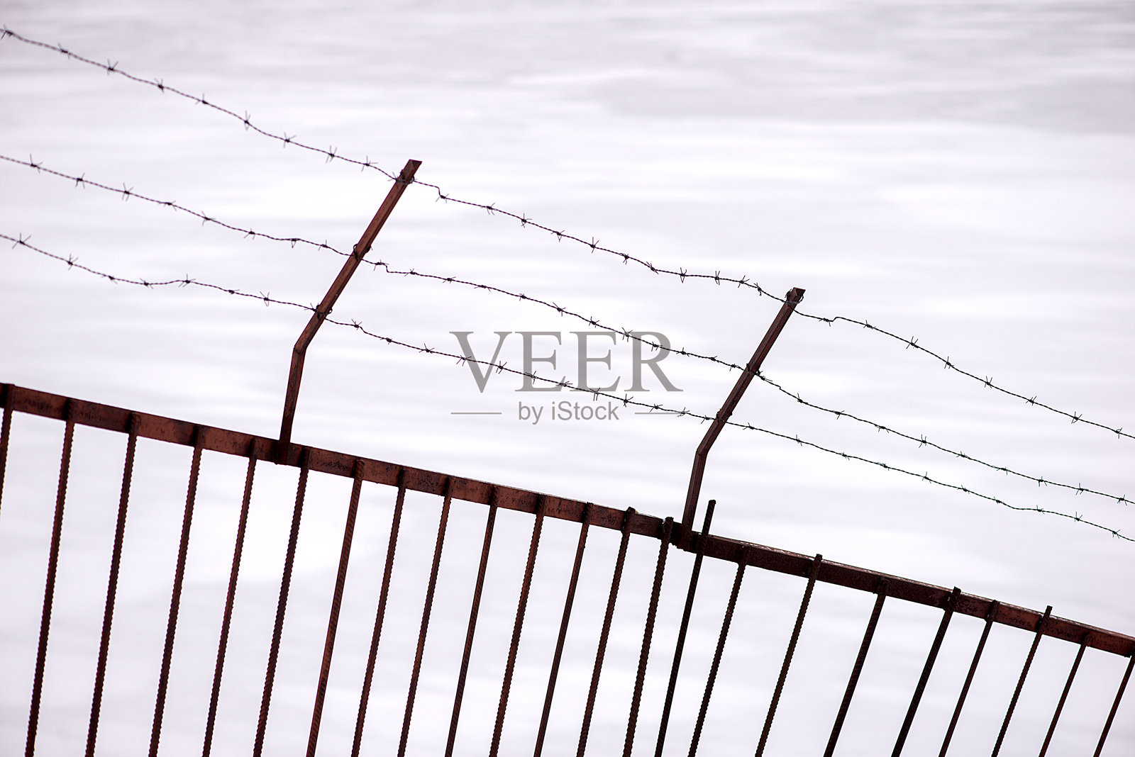 低角度视图的生锈铁丝网围栏与天空相对照片摄影图片