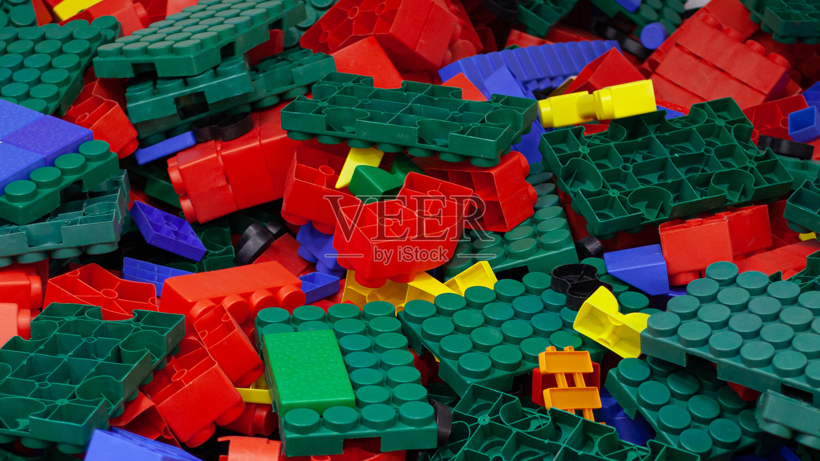 儿童塑料积木的特写。不同形状的玩具砖堆在一起。照片摄影图片