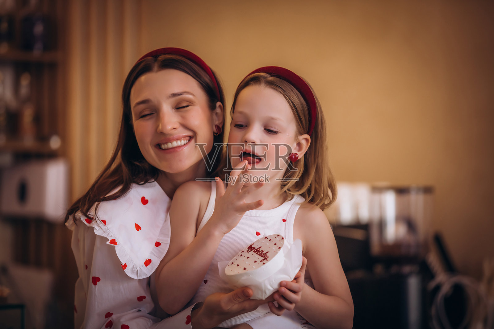 母女在咖啡馆里一起庆祝节日,享用蛋糕,快乐而甜蜜。照片摄影图片