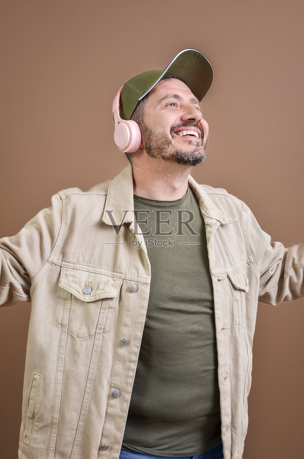 快乐的男人戴着无线耳机听音乐并跳舞照片摄影图片