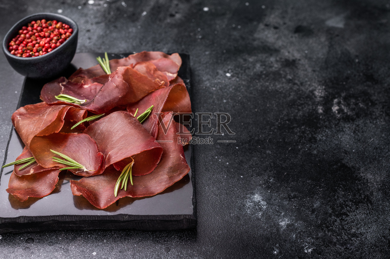 西班牙干肉片塞西纳,西班牙小吃。黑色背景。俯视图照片摄影图片