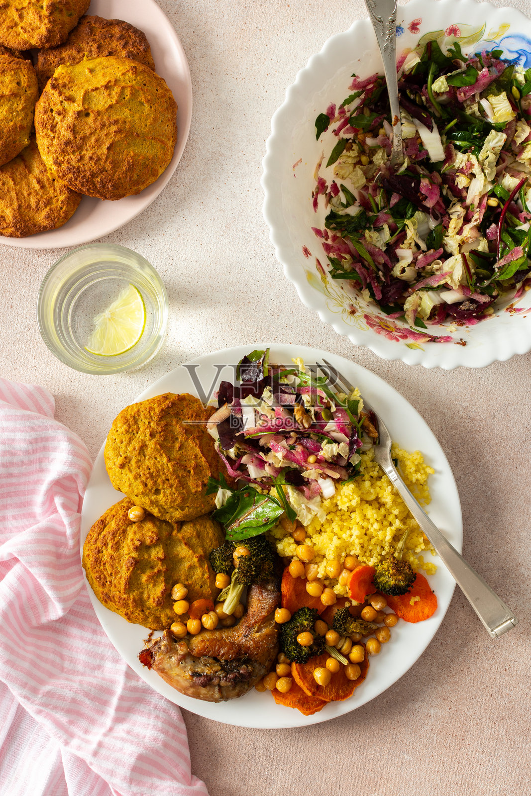 一顿丰盛均衡的早餐,包括扁豆和西葫芦煎饼、黍米、烤鸡脖、烤红薯、西兰花、胡萝卜、鹰嘴豆,以及配有萝卜、豆芽和坚果的新鲜沙拉。照片摄影图片