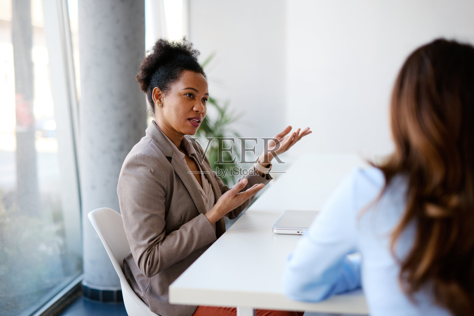 现代办公室中,女商人在会议上讨论。照片摄影图片