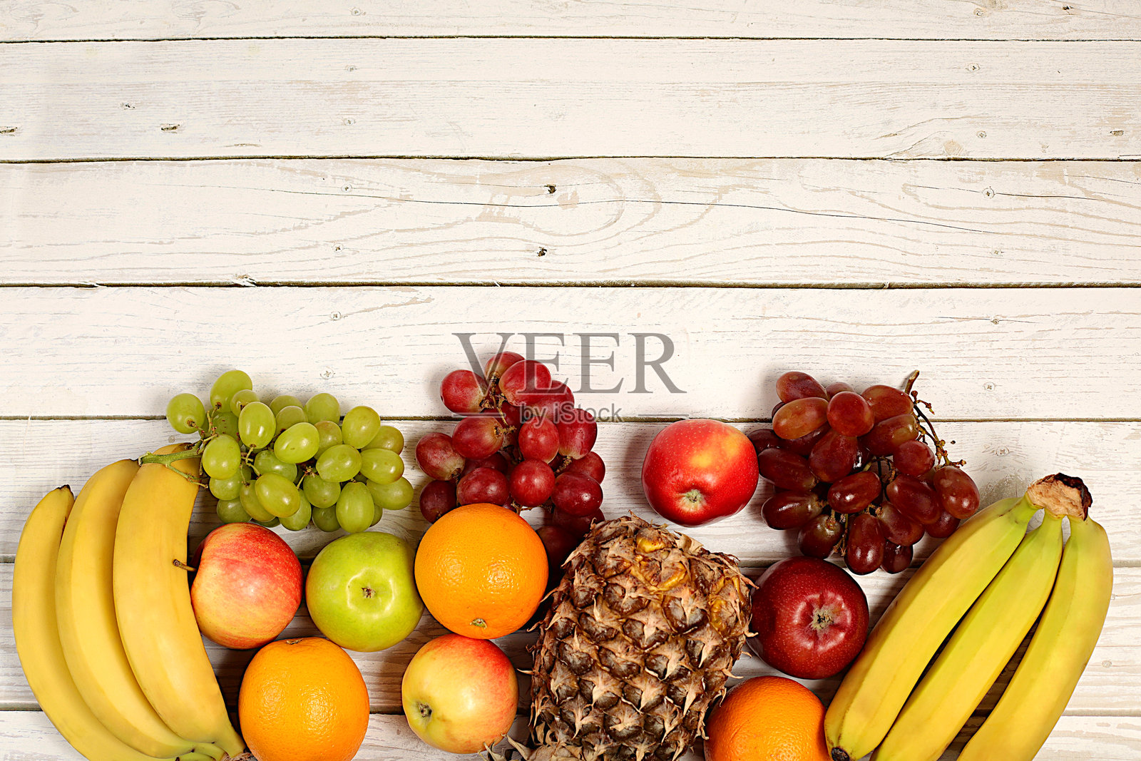 健康生活方式的健康素食产品。木质背景上的葡萄、橙子、菠萝、苹果、香蕉、坚果和天然果汁,排毒饮食和减肥概念,商店广告。照片摄影图片