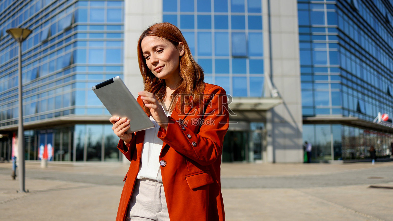 一位美丽的女士在城市环境中使用平板电脑阅读照片摄影图片