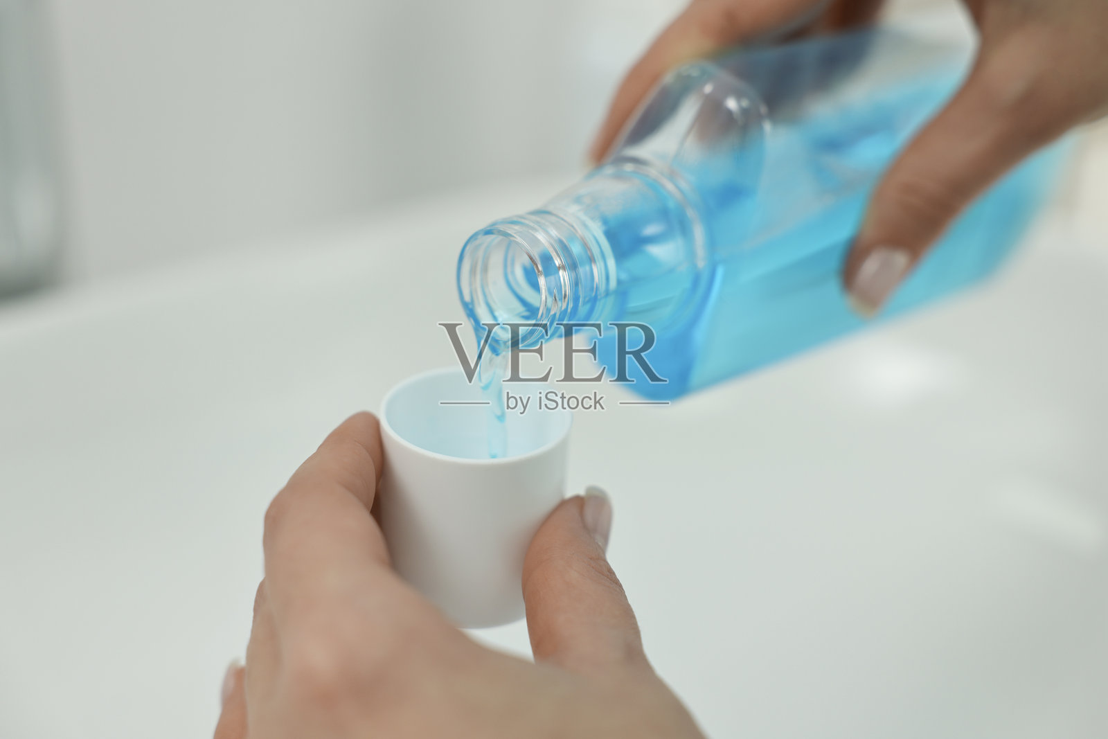 年轻女性在浴室洗手池上方漱口,特写镜头照片摄影图片