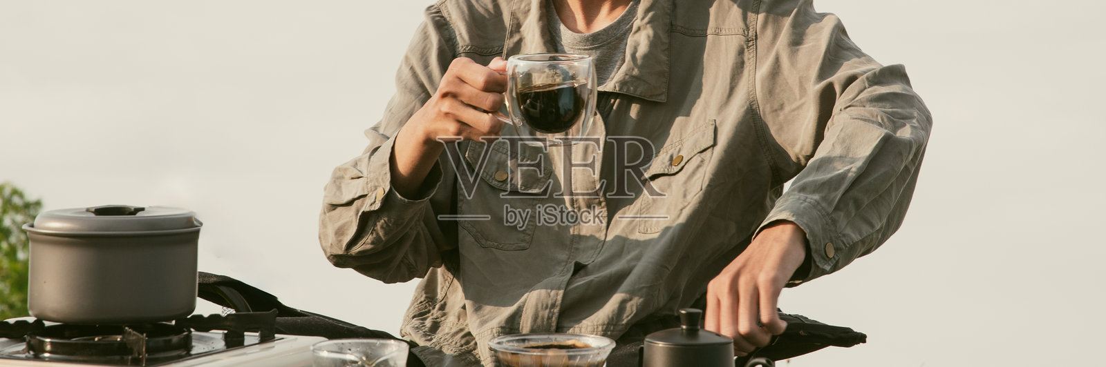 早晨咖啡概念,专注于与自然和谐共生的咖啡,采用有机种子,创造温暖的咖啡杯,背景为绿色新鲜的户外。香气四溢的饮品,浓郁的香味从杯中升起。照片摄影图片