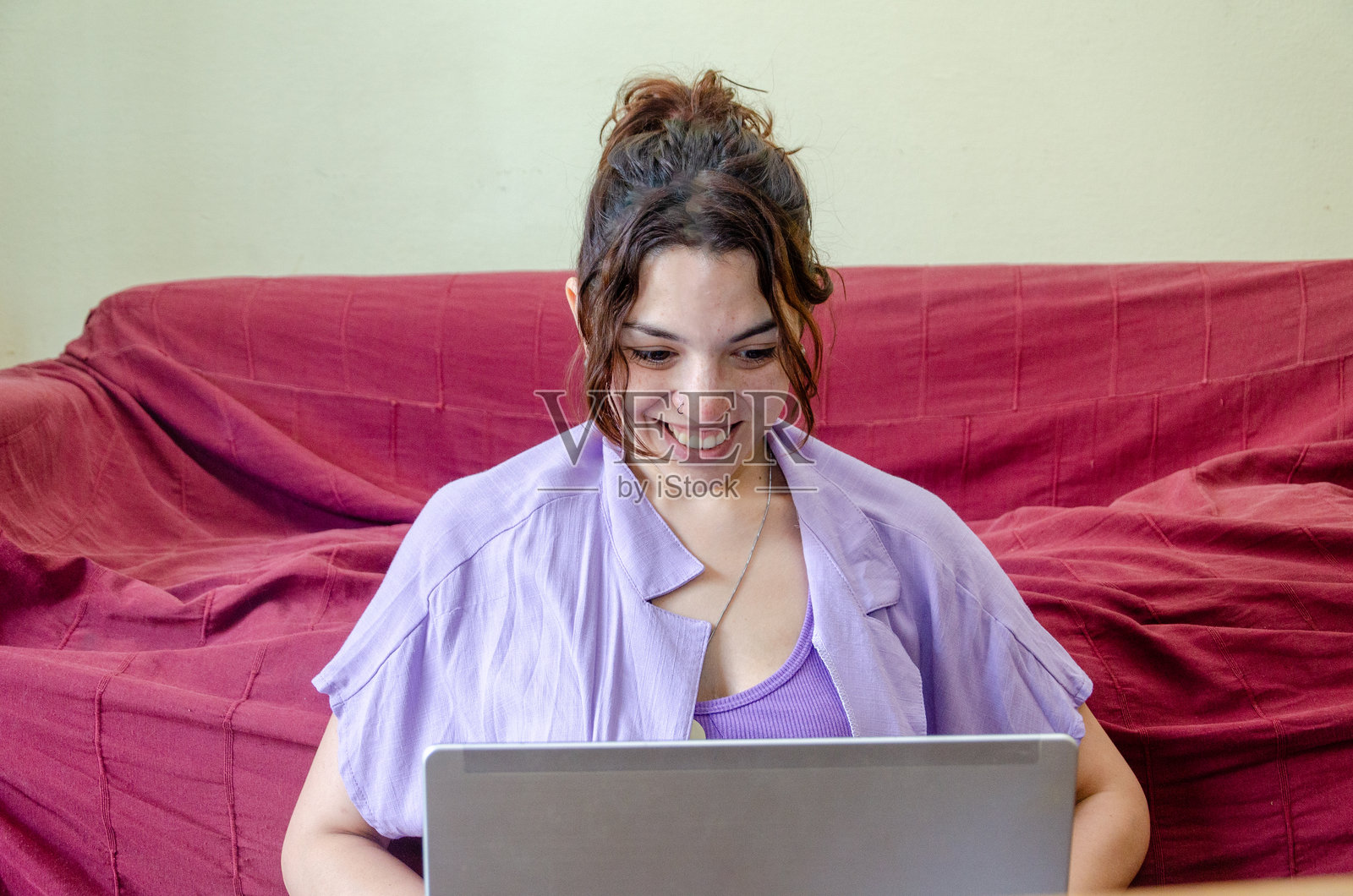 放松并微笑的女性员工或学生在用笔记本电脑进行视频通话照片摄影图片